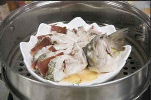 將鱸魚成花狀擺好，將火腿切片放入各縫隙中，放入鍋中隔水蒸12分鐘拿出，撒上蔥花即可。