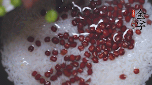 將炒好的食材和大米、紅豆一起放進(jìn)電飯鍋煮。