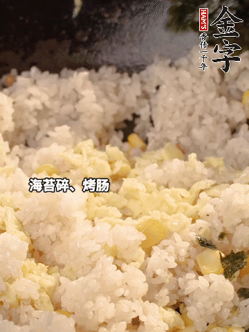 剩米飯下鍋炒散，依次下玉米粒、雞蛋、烤腸、海苔碎翻炒均勻。