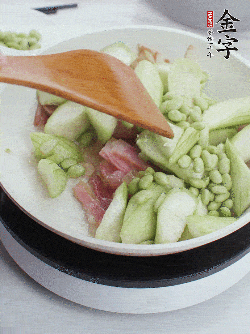 依次下絲瓜、青豆翻炒，炒至絲瓜打蔫縮小。