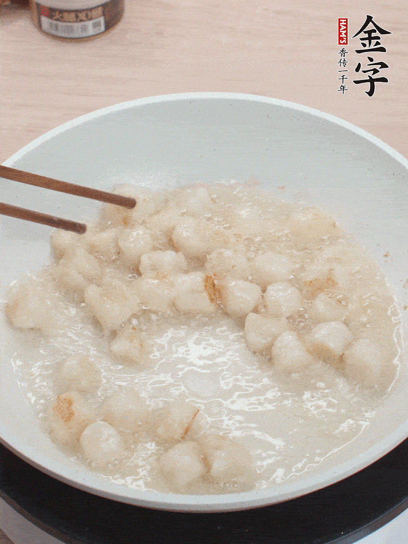 油溫4成熱，鮮貝蘸干淀粉下鍋煎，一面微黃后翻面。