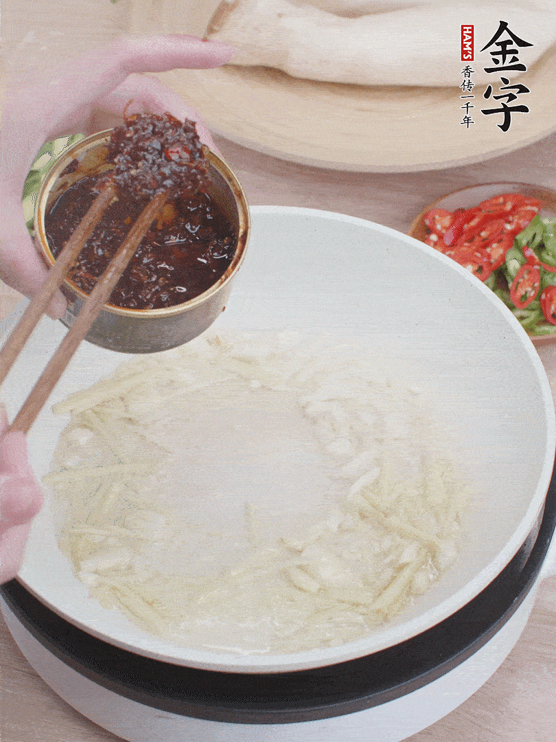 起鍋熱油，姜蒜、金字火腿干貝醬煸香。