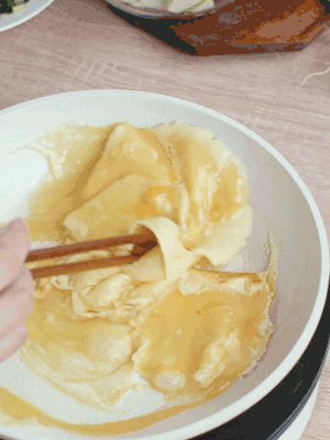 油6成熱時(shí)，下雞蛋液，邊緣凝固時(shí)翻拌成塊狀。