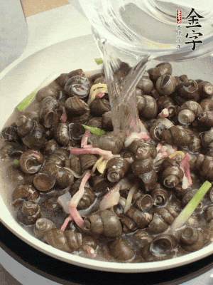 倒處理干凈的螺螄翻炒，加3勺料酒。加清水蓋過螺螄，中火蓋蓋煮5分鐘。