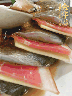 魚肚中塞蔥結(jié)、火腿片，魚身上碼放姜片、火腿片，倒入混合的料汁。