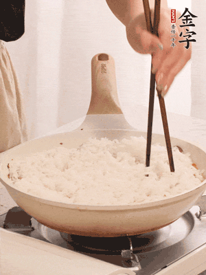 把瀝干水分的米飯均勻鋪在上面，筷子戳幾個洞，以便透氣，轉(zhuǎn)小火蓋上蓋子燜至水分收干，大概10分鐘。